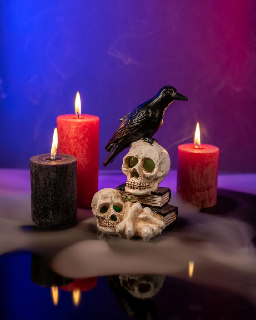 Crow figure sitting on the skulls and bones with candles and smoke.